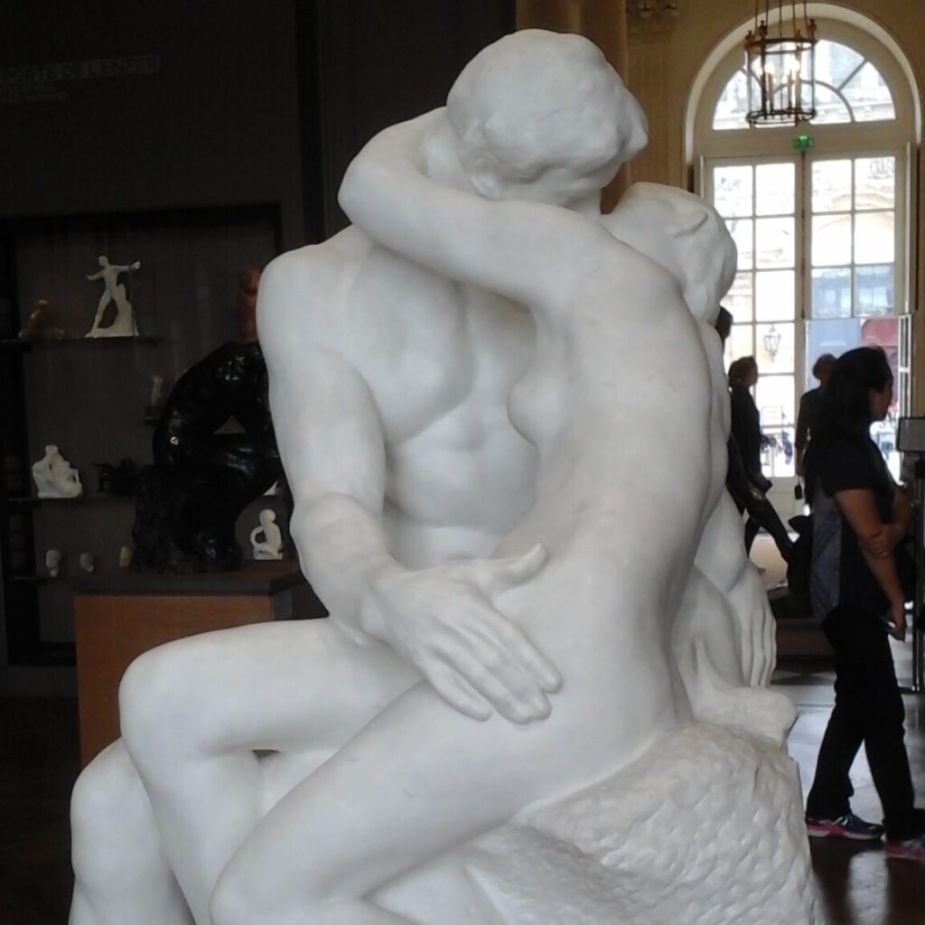 A marble sculpture of a naked man and a woman kissing each other